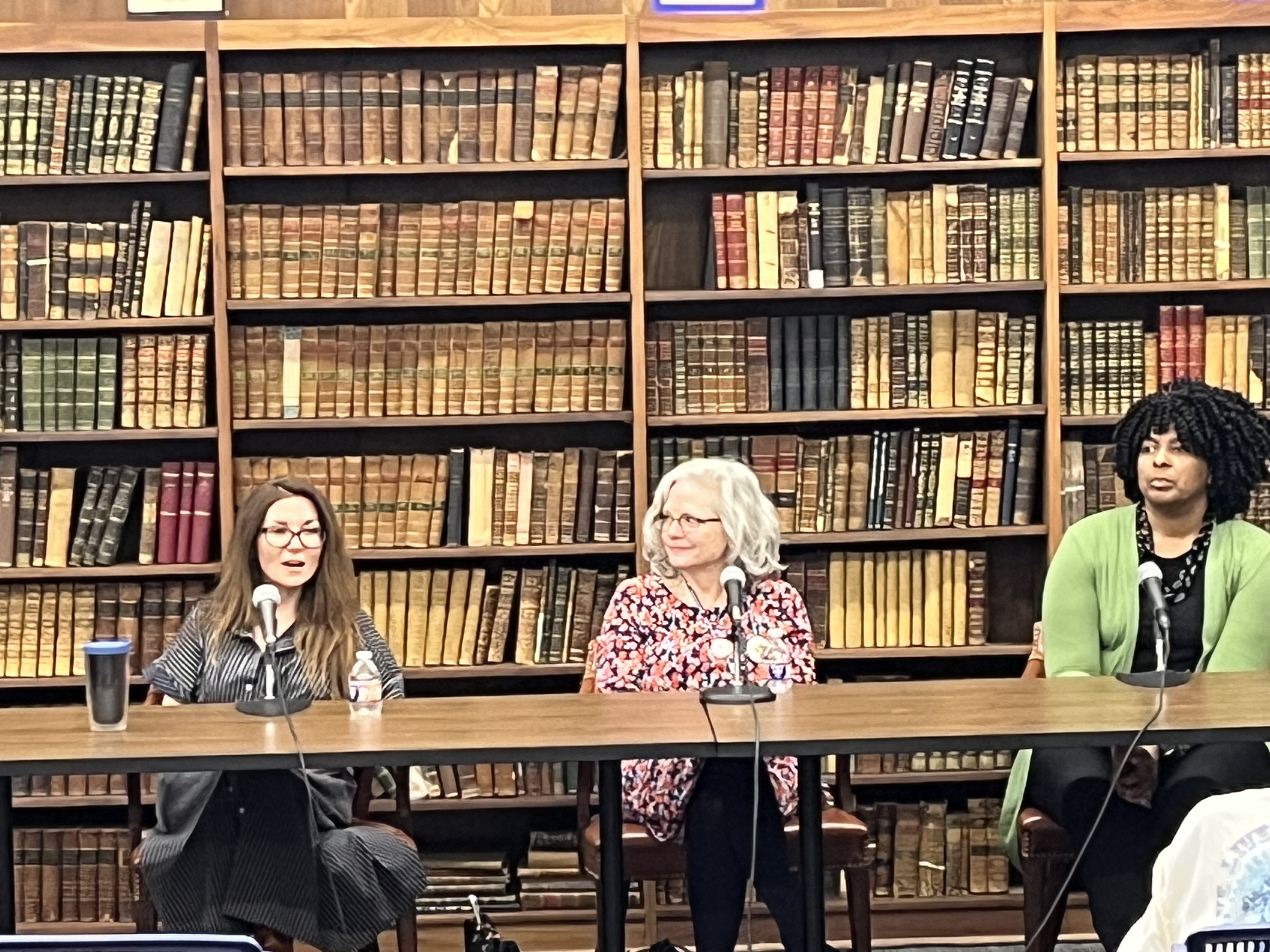 Three women who are medical professionals sit at a table and talk about their careers.