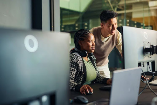 Two cloud security engineers working on a computer.
