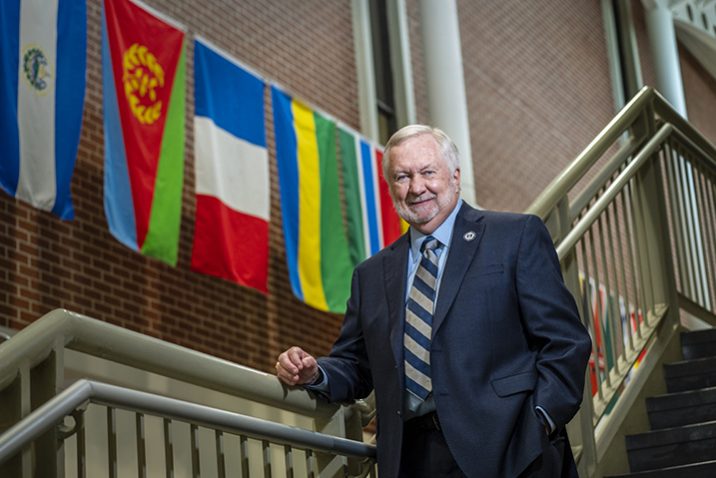 Man on stairs with flags in background