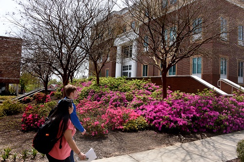 Two students walking in front of a building