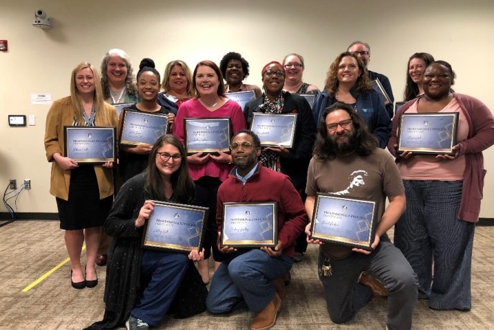 group of people holding certificates