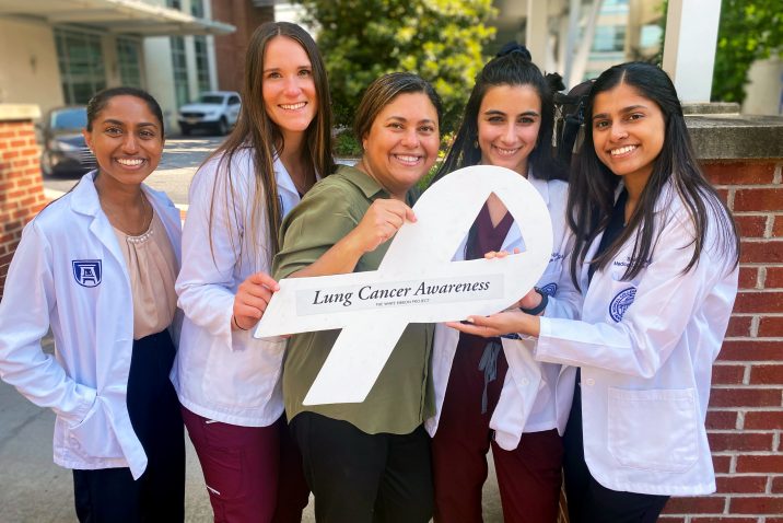 Five women holding a white ribbon to represent lung cancer awareness