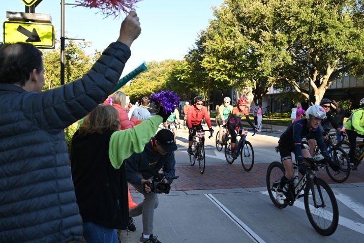 People are standing outside the Georgia Cancer Center's M. Bert Storey Research Building cheering and celebrating particpants taking part in PaceDay 2023.