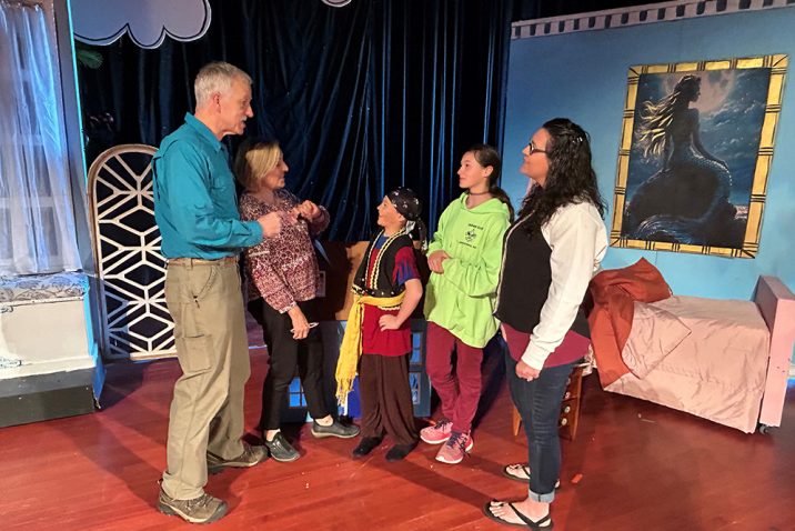 Man and woman talking with children and an adult woman