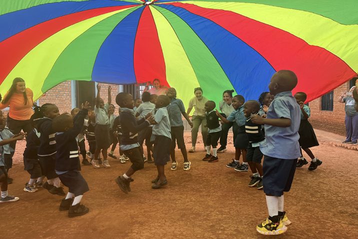 Children playing under a colorful tarp