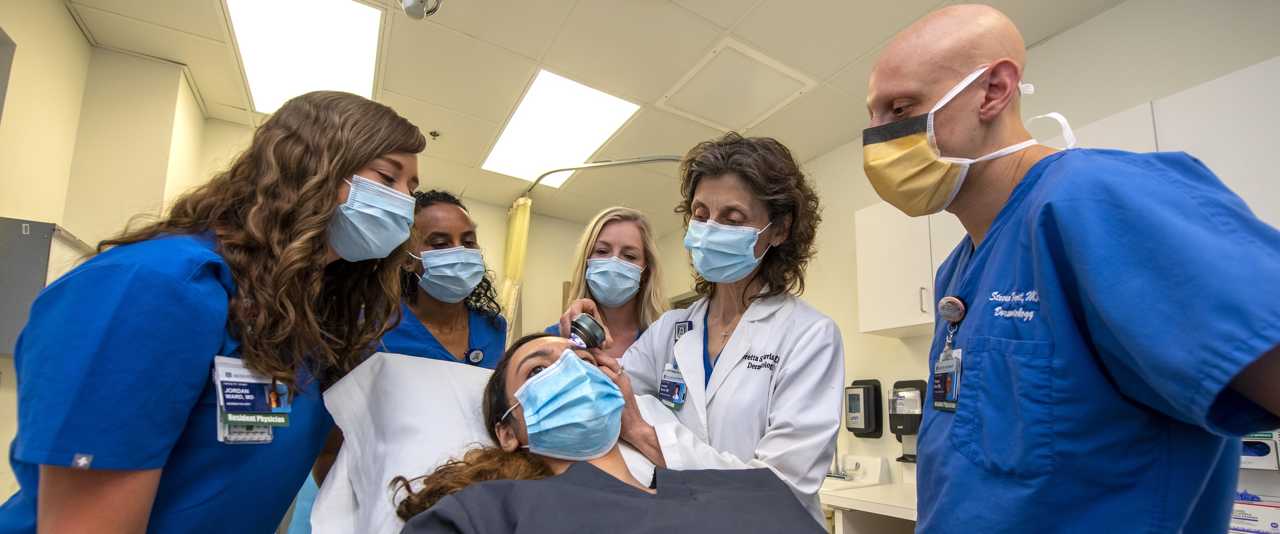 Dermatology residents looking at patient