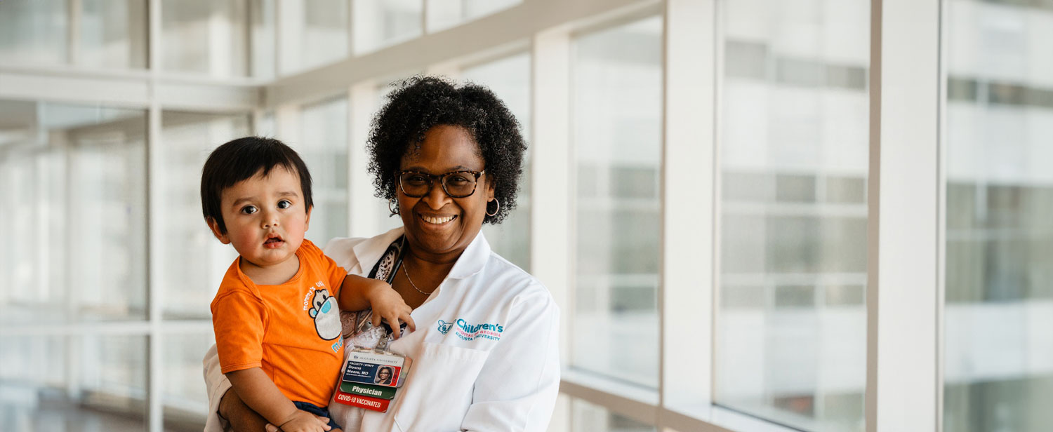 Dr. Moore and child pose for camera