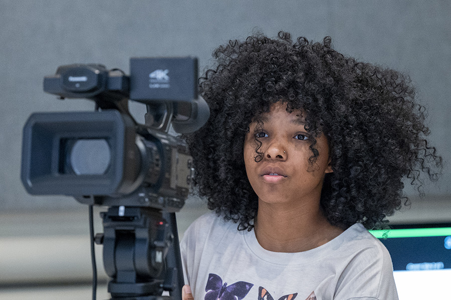 Communication student behind video camera
