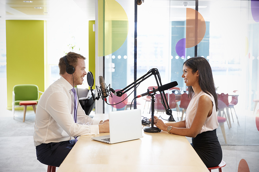 Podcast interview - Two podcasters sitting across from each other at microphones