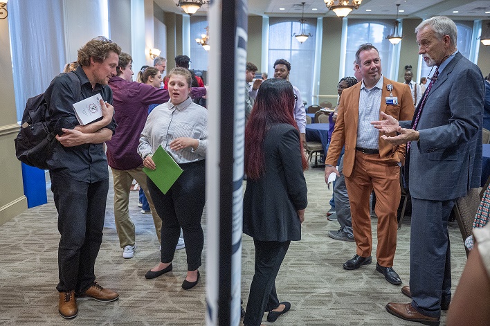 Conference members presenting posters to the Provost