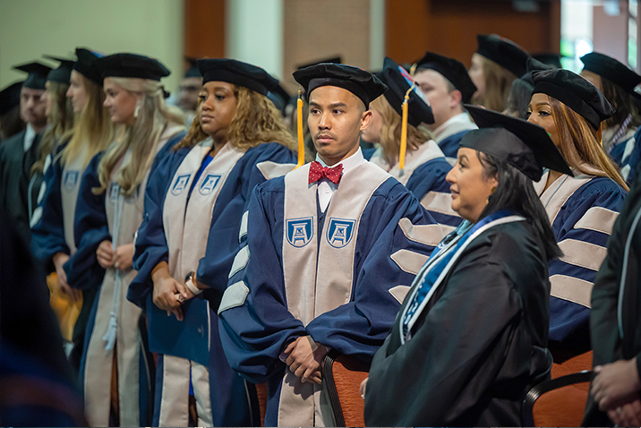 Graduate students in caps and gowns at commencement