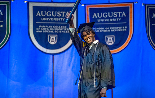 Graduate celebrates as he walks across the stage