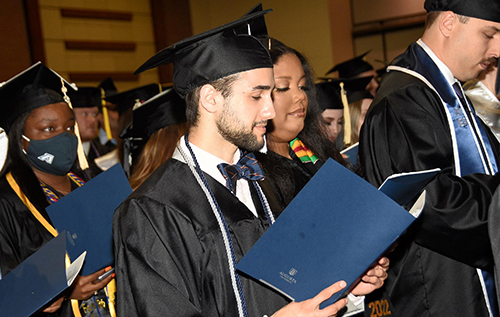 Graduates look at program during 毕业典礼