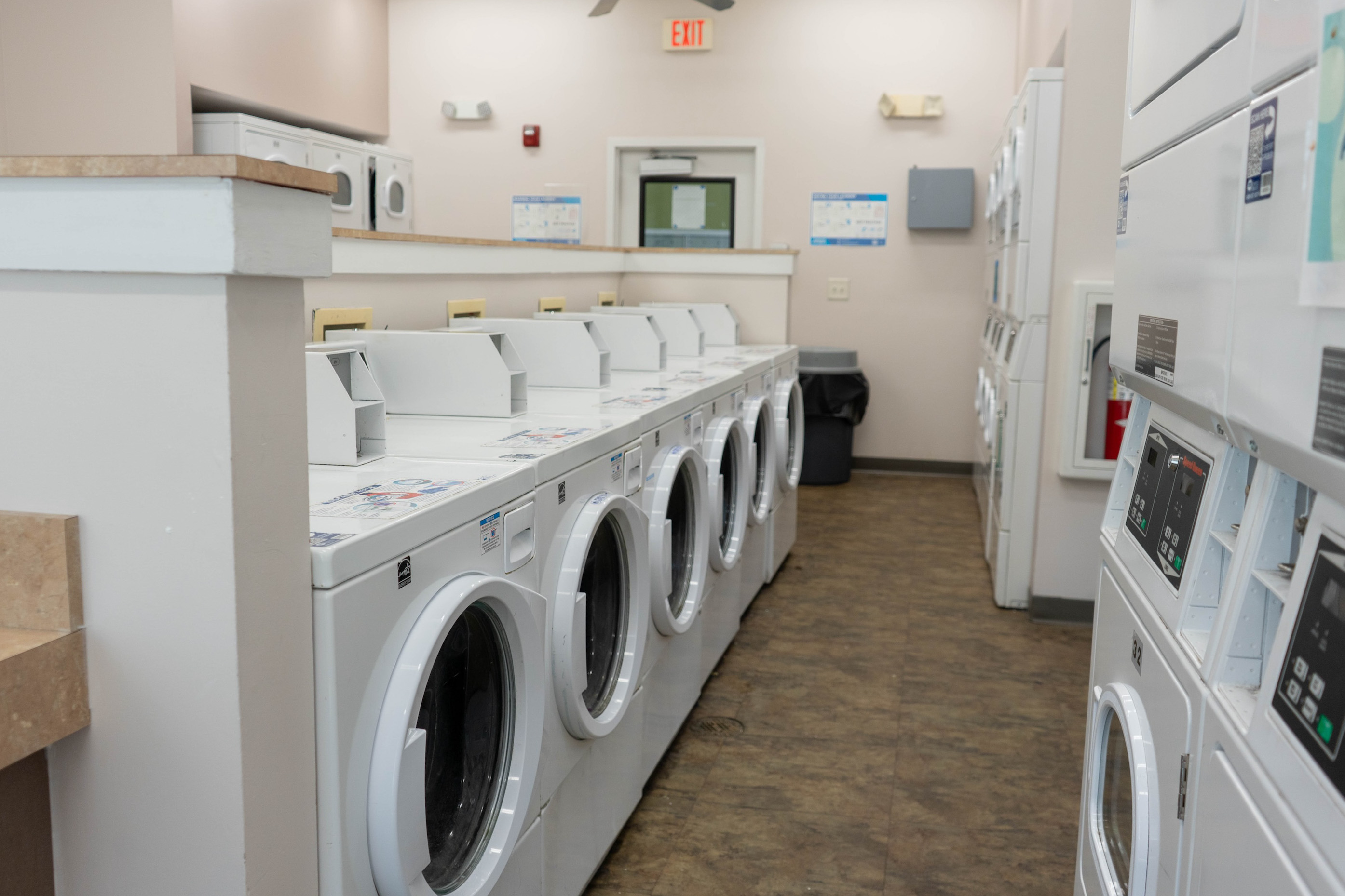 Shared large laundry room showing multiple washers and dryers 