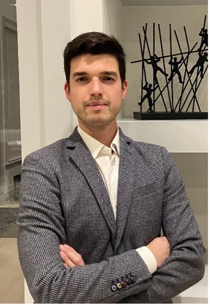 A man in a suit standing with arms crossed