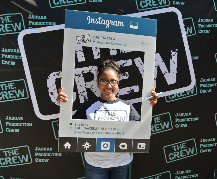 Female student holding a mock Instagram square around her face