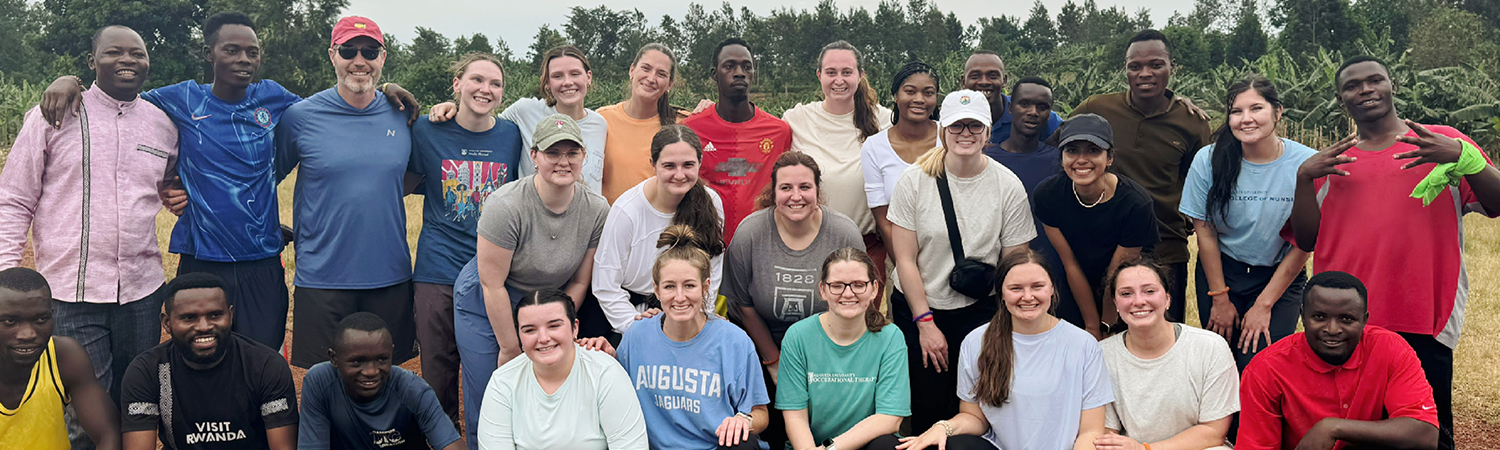 Augusta University Professor Ryan Carrick poses with a group of students in Rwanda