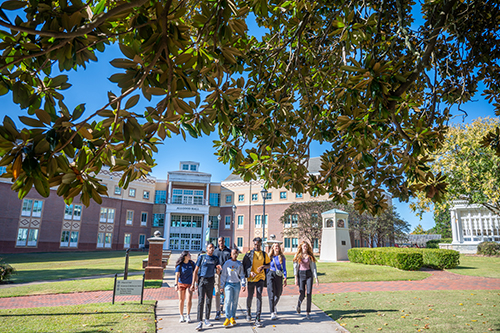 A group of students walking into the grove from Allgood Hall